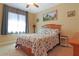 Bedroom with neutral walls, a ceiling fan, and a bed with floral bedding, creating a comfortable atmosphere at 6104 Hunters Ridge Ave, Leesburg, FL 34748