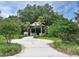 View of the community's entrance featuring a branded portico, lush landscaping and a walkway at 6104 Hunters Ridge Ave, Leesburg, FL 34748