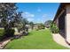 Beautifully landscaped front yard with lush green grass, trees, and bushes, enhancing the home's curb appeal at 6104 Hunters Ridge Ave, Leesburg, FL 34748