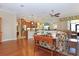 Open-concept living area with hardwood floors, ceiling fan and view into the kitchen at 6104 Hunters Ridge Ave, Leesburg, FL 34748