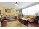 Bright living room with hardwood floors, comfortable seating, and large windows providing plenty of natural light at 6104 Hunters Ridge Ave, Leesburg, FL 34748