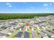 Aerial view of community with a red marker, showcasing homes, lawns, lake, and surrounding landscape at 6471 Ecoff Pl, The Villages, FL 34762