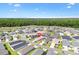 Gorgeous aerial view of a single-story home in a scenic community near a lake and lush forest backdrop at 6471 Ecoff Pl, The Villages, FL 34762