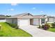 Inviting single-story home with a concrete driveway and a two car garage at 6471 Ecoff Pl, The Villages, FL 34762
