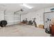 Spacious garage with a roll up door and bikes inside at 6471 Ecoff Pl, The Villages, FL 34762