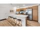 Beautiful kitchen with stainless steel refrigerator, countertop seating and wood cabinets at 6471 Ecoff Pl, The Villages, FL 34762