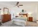 This primary bedroom is nicely appointed with a ceiling fan, dresser, and bedside tables at 732 Ramirez Ave, The Villages, FL 32159