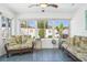Sunroom showcasing a ceiling fan, blue flooring, and sliding glass door access to the yard at 732 Ramirez Ave, The Villages, FL 32159