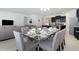 Open concept dining room with modern chandelier, seating for six and view to the kitchen at 8024 Oak Shadow Ct, Davenport, FL 33837