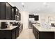 Modern kitchen with dark cabinets, stainless steel appliances, and white countertops at 8024 Oak Shadow Ct, Davenport, FL 33837