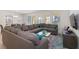 Spacious living area with grey sectional couch, neutral walls, and a view of the backyard at 8024 Oak Shadow Ct, Davenport, FL 33837