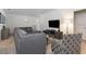 Comfortable living room featuring a gray sofa, modern TV, and stylish decor at 8024 Oak Shadow Ct, Davenport, FL 33837