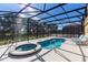 Screened-in pool and spa area, complete with outdoor lounge chairs and a blue sky at 8024 Oak Shadow Ct, Davenport, FL 33837