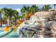 Exterior view of community water park showcasing rock waterfall and orange water slide at 8024 Oak Shadow Ct, Davenport, FL 33837