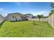 Expansive backyard featuring lush green grass, a white fence, and a screened patio at 8272 Procida Isle Ln, Windermere, FL 34786
