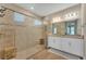 Bright bathroom featuring a large walk-in shower with neutral tile, dual sinks, and modern fixtures at 8272 Procida Isle Ln, Windermere, FL 34786