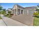 Beautiful home features a two-car garage, brick paved driveway, stone accents, and manicured landscaping at 8272 Procida Isle Ln, Windermere, FL 34786
