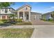 Charming home with two-car garage, stone accents, manicured landscaping, and a brick-paved driveway at 8272 Procida Isle Ln, Windermere, FL 34786