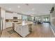 Open-concept kitchen featuring a large island with seating, stainless steel appliances, and a view into the living area at 8272 Procida Isle Ln, Windermere, FL 34786