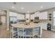Bright kitchen features a curved island with white cabinetry and barstool seating at 8272 Procida Isle Ln, Windermere, FL 34786