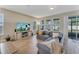Living room featuring a comfortable gray sofa, large windows, and a media center at 8272 Procida Isle Ln, Windermere, FL 34786