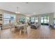 Open-concept living and dining area with hardwood floors and plenty of natural light from large windows and sliding glass door at 8272 Procida Isle Ln, Windermere, FL 34786