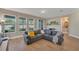 Cozy living room with a plush grey sectional, a music nook, and large windows overlooking the backyard at 8272 Procida Isle Ln, Windermere, FL 34786