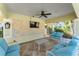 Covered outdoor patio with comfortable seating, a ceiling fan, and a mounted TV for relaxation and entertainment at 8272 Procida Isle Ln, Windermere, FL 34786