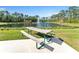 Scenic pond view with a fountain, picnic table, and lush greenery creating a tranquil atmosphere at 8272 Procida Isle Ln, Windermere, FL 34786