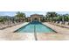 Community pool with lounge chairs, sun umbrellas, and a covered seating area for relaxing poolside at 8272 Procida Isle Ln, Windermere, FL 34786