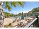 Community pool with lounge chairs, tables, sun umbrellas, and a covered seating area for relaxing poolside at 8272 Procida Isle Ln, Windermere, FL 34786