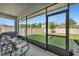Spacious screened patio with comfortable seating and a view of the green, fenced backyard at 8272 Procida Isle Ln, Windermere, FL 34786