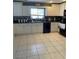Bright kitchen with white cabinets, tile flooring, and black appliances creating a sleek, modern look at 879 Little Bend Rd, Altamonte Springs, FL 32714
