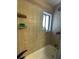 Tiled shower and bath combination with window and built in shelving at 879 Little Bend Rd, Altamonte Springs, FL 32714