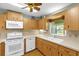 Bright kitchen features wood cabinets, white appliances, window over sink, and a ceiling fan at 8814 Sw 93Rd Ln # B, Ocala, FL 34481