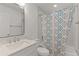Bright bathroom featuring modern fixtures, including a new vanity and shower with patterned curtain at 909 Cajon Ct, The Villages, FL 32159