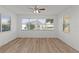 A sunlit bedroom featuring light wood floors and windows with views of the outdoors at 909 Cajon Ct, The Villages, FL 32159