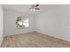 A bright bedroom featuring light wood floors and a window overlooking a grassy area at 909 Cajon Ct, The Villages, FL 32159