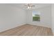 A well-lit bedroom featuring light wood floors, a ceiling fan, and a large window at 909 Cajon Ct, The Villages, FL 32159