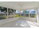 A bright sunroom featuring white tile floors and windows with views of a lush yard at 909 Cajon Ct, The Villages, FL 32159