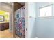 Shower area featuring colorful patterned curtain, tiled walls, and a glimpse into another bathroom at 1111 Myrtle Breezes Ct, Fruitland Park, FL 34731