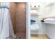 Bathroom featuring a shower with neutral tiling next to a closet with shelves and textiles at 1111 Myrtle Breezes Ct, Fruitland Park, FL 34731