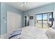 Bright bedroom with blue walls, closet, and balcony access with peaceful water views at 1111 Myrtle Breezes Ct, Fruitland Park, FL 34731