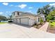 Gorgeous home featuring a three-car garage, driveway, and beautifully landscaped surroundings at 1111 Myrtle Breezes Ct, Fruitland Park, FL 34731