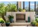 Outdoor fireplace with decorative plants and a glimpse of the pool and greenery at 1111 Myrtle Breezes Ct, Fruitland Park, FL 34731