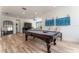 Inviting game room features wood floors, a billiard table, stylish decor, and comfortable seating areas at 1111 Myrtle Breezes Ct, Fruitland Park, FL 34731