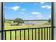 Balcony view showcasing a serene lake, lush green grass, and blue skies with clouds at 1111 Myrtle Breezes Ct, Fruitland Park, FL 34731
