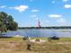 Lakefront property featuring a fire pit, boat, and dock in a serene setting under a bright blue sky at 1111 Myrtle Breezes Ct, Fruitland Park, FL 34731