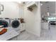 Well-equipped laundry room with white cabinets and modern washer and dryer units at 1111 Myrtle Breezes Ct, Fruitland Park, FL 34731