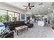 Open-concept living room boasts a modern ceiling fan, neutral tones, and access to the outdoor living space at 1111 Myrtle Breezes Ct, Fruitland Park, FL 34731